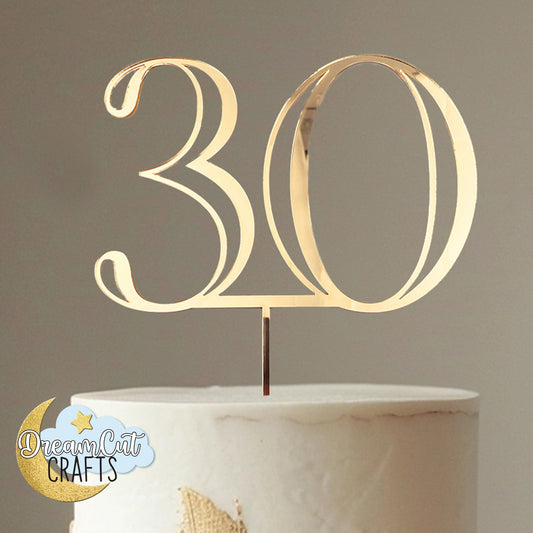 Gold '30' cake topper on a marble cake with DreamCat Crafts logo.