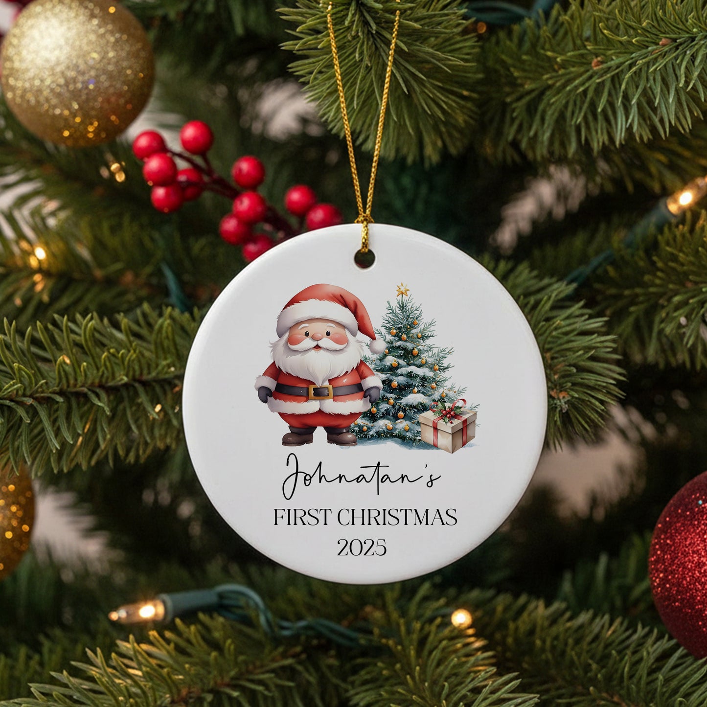 Round ceramic Christmas ornament with Santa, decorated tree and gift, personalized with name and year for baby’s first Christmas.