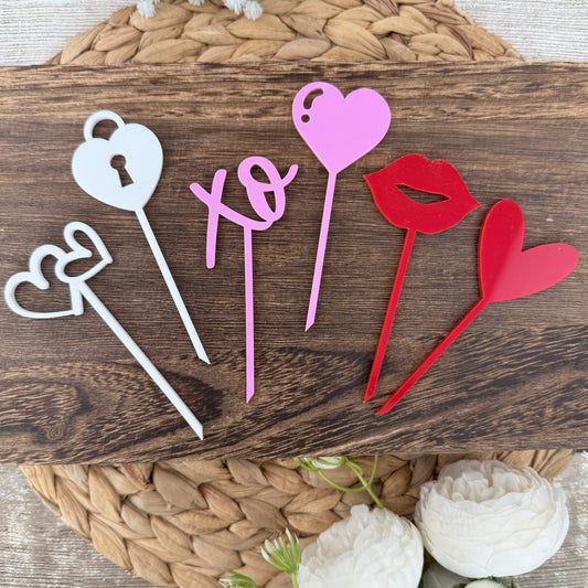 Set of Valentine acrylic cupcake toppers with hearts, XO, heart lock, lips, in pink, red, and white colors